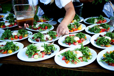 Midsection of waitress preparing salad