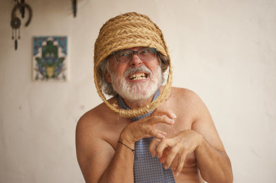 Portrait of shirtless man holding camera