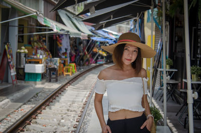 Portrait of woman standing at railroad station platform