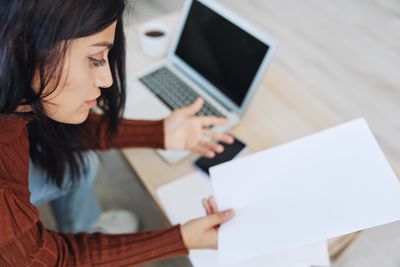 Midsection of woman using laptop while sitting on table