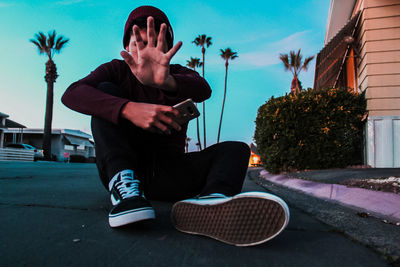 Young man sitting in front of building