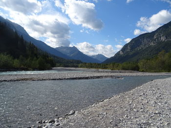 Scenic view of lake by mountains against sky