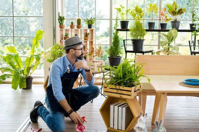 Gardener looking at plant at store