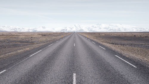 Road passing through landscape against sky