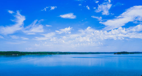 Scenic view of sea against blue and cloudy sky