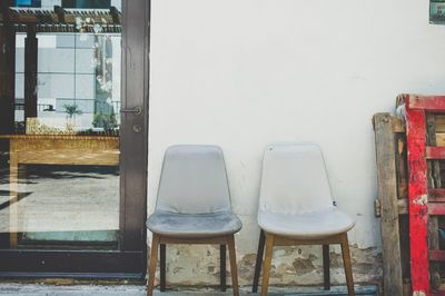 Empty chairs and tables against wall