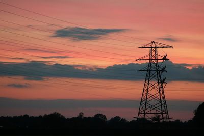 Low angle view of silhouette electricity pylon against sky during sunset