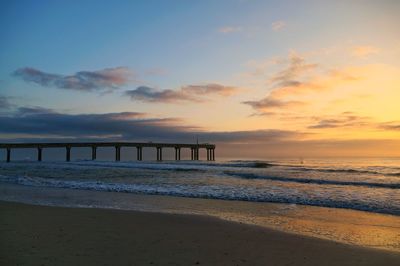 Scenic view of beach against sky during sunset