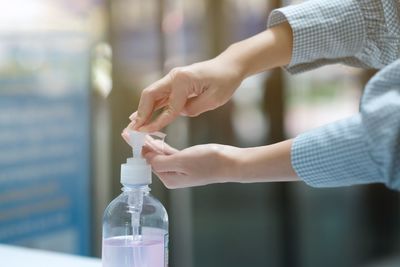 Close-up of woman hand holding bottle against blurred background