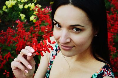 Portrait of smiling woman with red flower