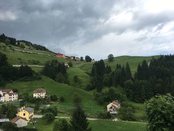 Houses on green landscape against sky