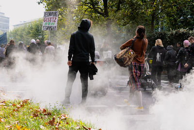 Rear view of people walking on street in city