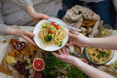 High angle view of woman holding food on table