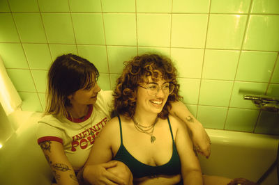 Portrait of smiling friends in bathroom