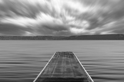 Pier over lake against sky