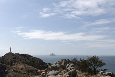 Scenic view of sea and cliff against sky