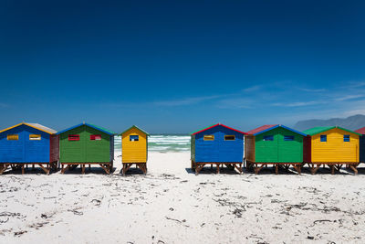 Beach hut against clear blue sky