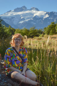 Portrait of smiling woman sitting on mountain