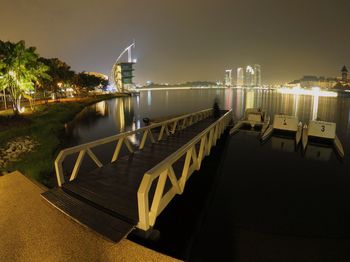 Illuminated bridge over river at night