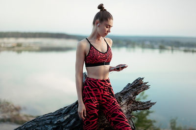 Young woman looking away while standing on rock