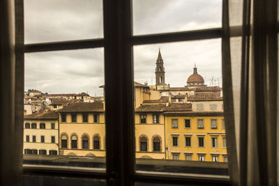 Buildings in city seen through glass window