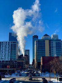 Modern buildings in city against blue sky