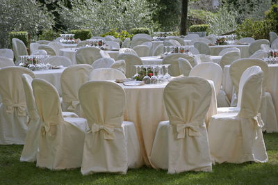 Round banqueting tables and chairs set up in the garden for wedding lunch