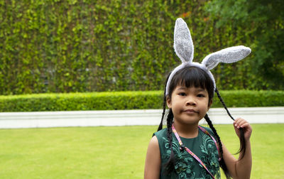 Portrait of cute little asian girl dresses casual standing on grass looking at camera.