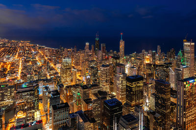 Illuminated cityscape against sky at night