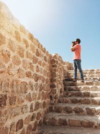 Full length of man standing on staircase against sky and talking photos of the old city