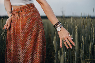 Midsection of woman standing on field