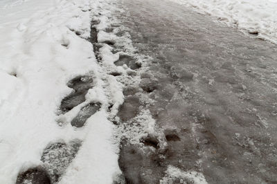 High angle view of footprints on snow covered land