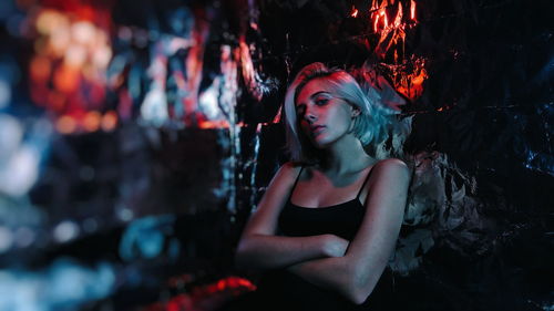 Portrait of young woman leaning on wall