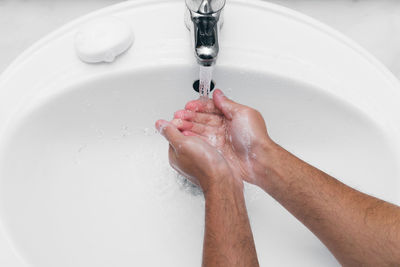 Close-up of human hand in bathroom