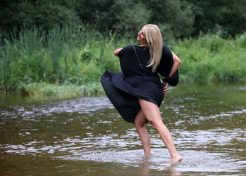 Full length of young woman dancing in lake