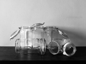 Close-up of glass jar on table against wall