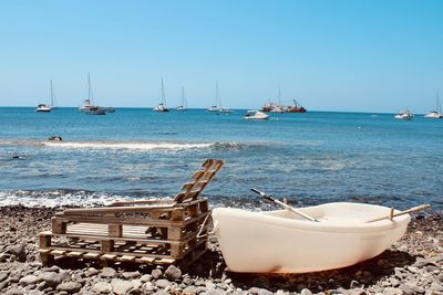 Boats in sea against clear sky