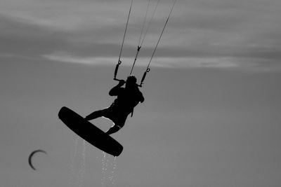 Low angle view of man paragliding against sky