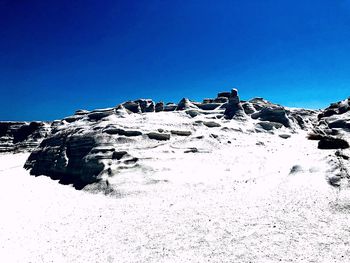 Scenic view of snowcapped mountains against clear blue sky