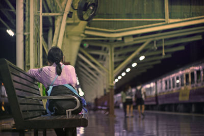 Rear view of woman on escalator at railroad station