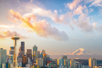 Buildings in city against sky during sunset