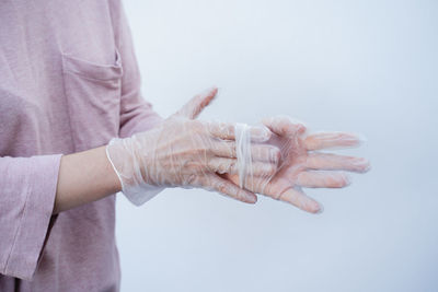 Close-up of hand holding hands over white background