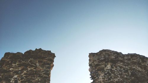 Low angle view of rock formation against clear blue sky