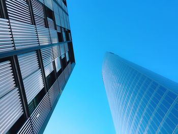 Low angle view of modern building against blue sky