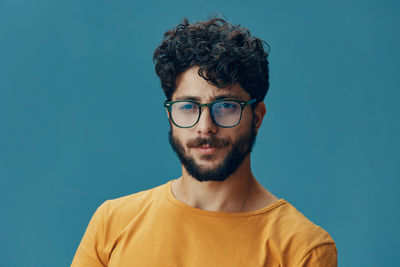 Portrait of young man against blue background