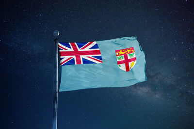 Low angle view of fijian flag against star field sky