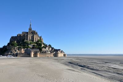 Built structure on beach against clear blue sky