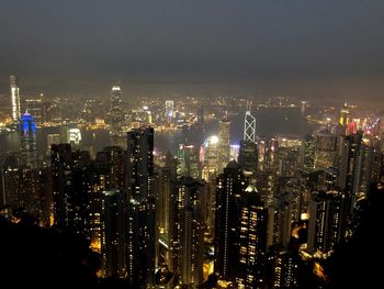 Illuminated cityscape against sky at night