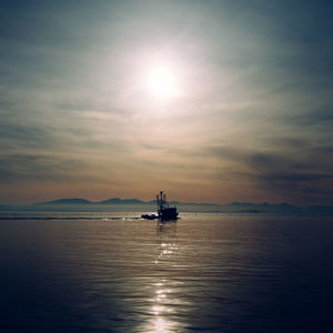 Silhouette ship sailing on sea against sky during sunset