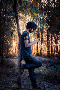 Side view of young man in forest
